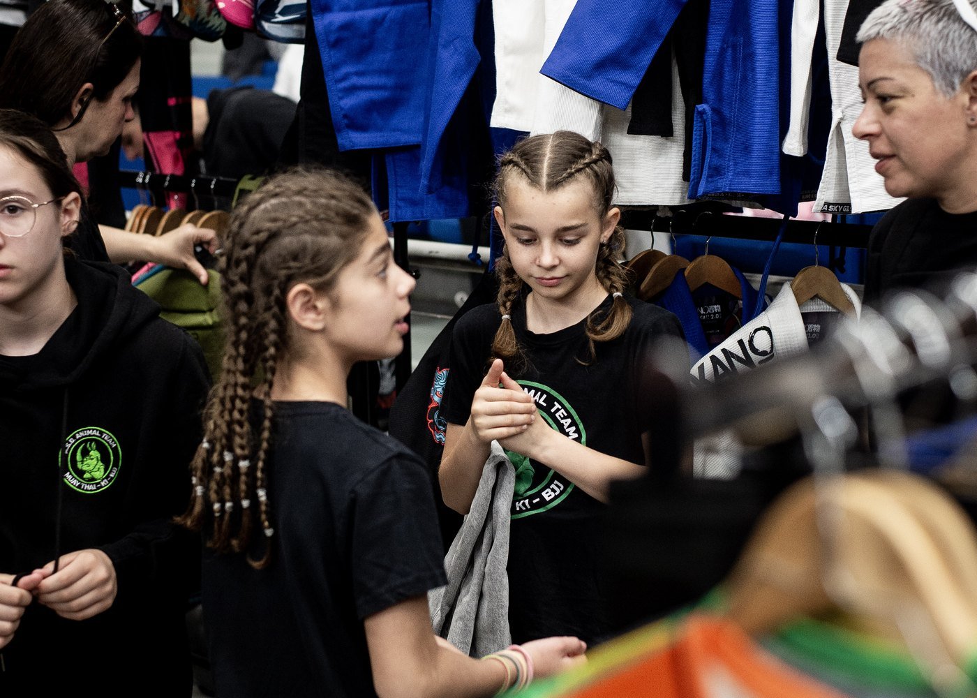 Customers browsing a rail of BJJ gis and kimonos at a Kano Kimonos shop